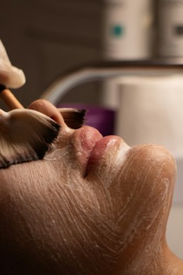 Cream being brushed onto a face